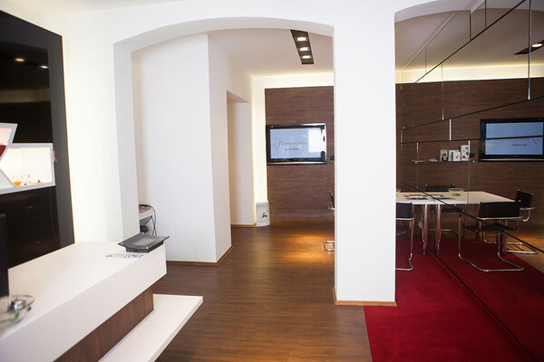 Modernes Büro mit Empfangsbereich, Konferenztisch, Holzfußboden und stilvoller Einrichtung.